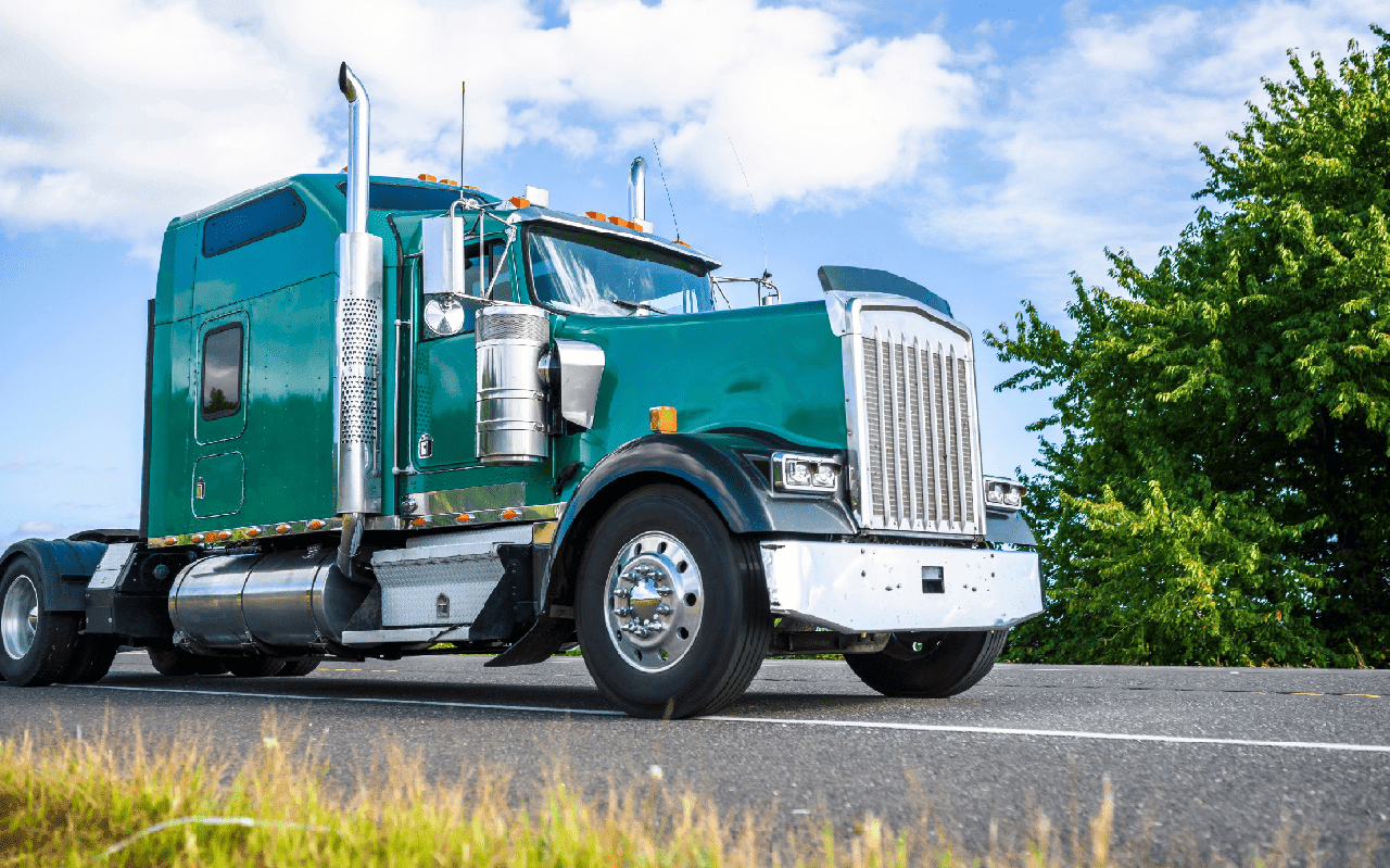 Green big rig semi truck tractor with cab designed for reduce air resistance and improve aerodynamic characteristics driving on the road in Columbia Gorge for pick up loaded semi trailer